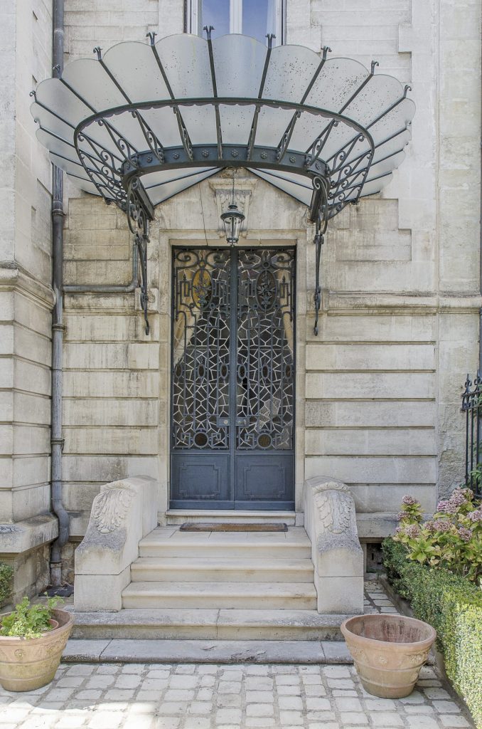 Elaborate marquise in Périgueux showing intricate wrought iron glazed canopy making a grand entrance