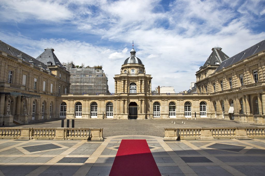 The French Sénat at the Palais de Luxembourg in Paris, showing the grand entrance with red carpet and classical architecture